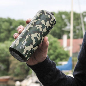 The Sitpack 2.0 in green camo folded up to the size of a 50cl can and being held in a hand.